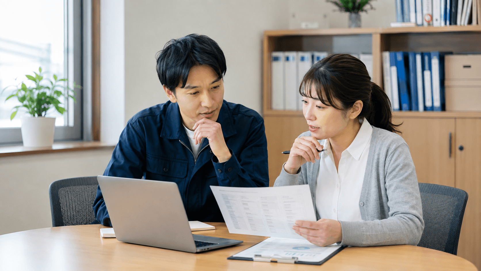 地域企業の担当者2人が、ノートPCと問い合わせ一覧を見ながら、AIが返答しない質問のルールを相談している様子